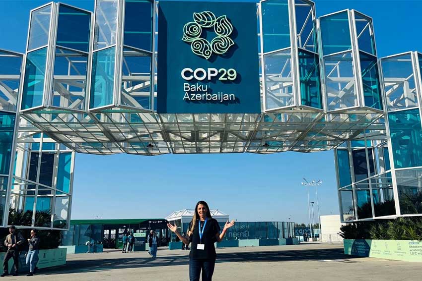 AUT Professor Erica Hinckson standing infront of Cop29 sign.