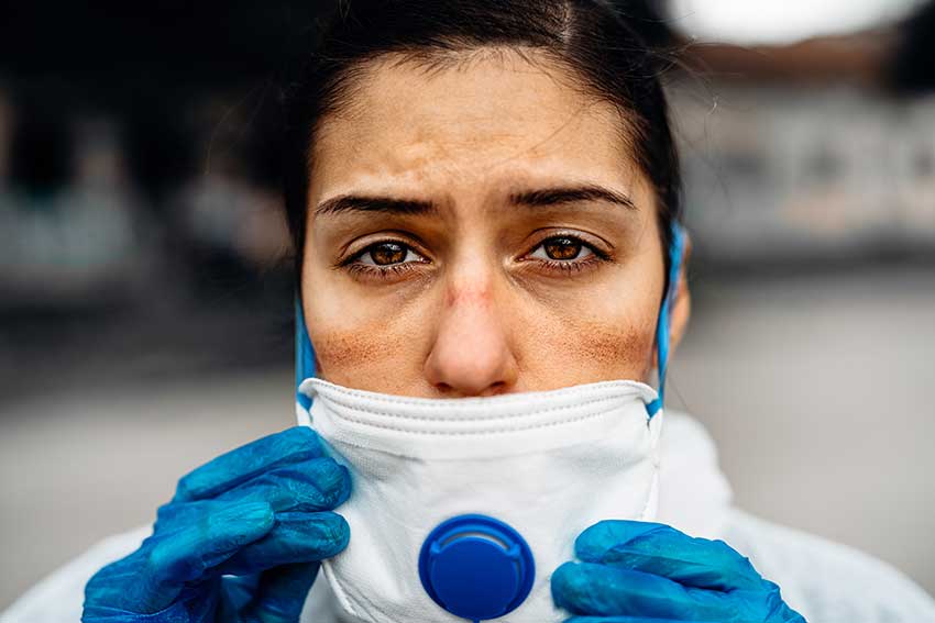 Exhausted doctor/nurse wearing protective mask.