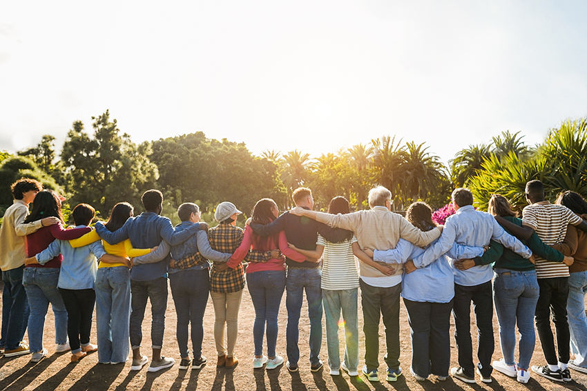 Group of multigenerational people hugging each other.