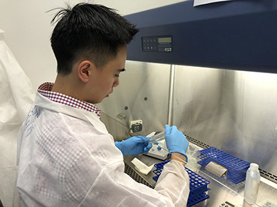 MLS Lon Hua looking closely at a sample